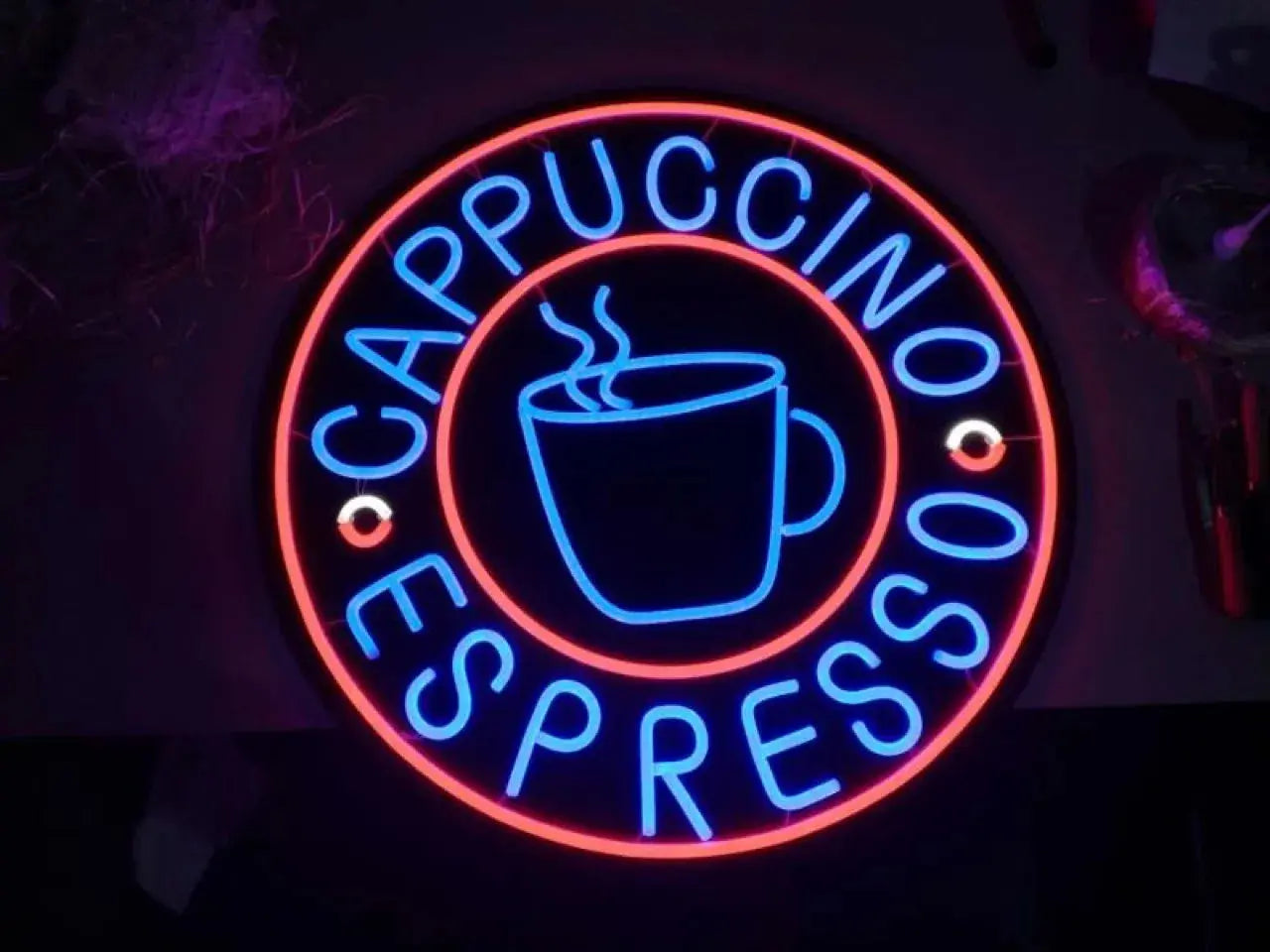 Enseigne néon ronde cappuccino espresso avec icône tasse de café lumineuse en bleu et rouge dans un intérieur de café
